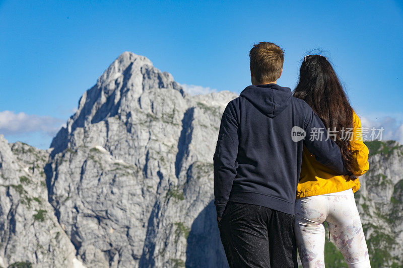 年轻夫妇站在山顶上看风景