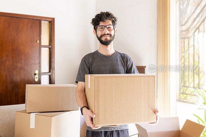 拉美裔男子拿着箱子。搬家的概念