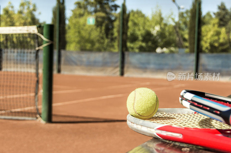 网球拍和球，放在一个砖灰的球场上。网球的概念。