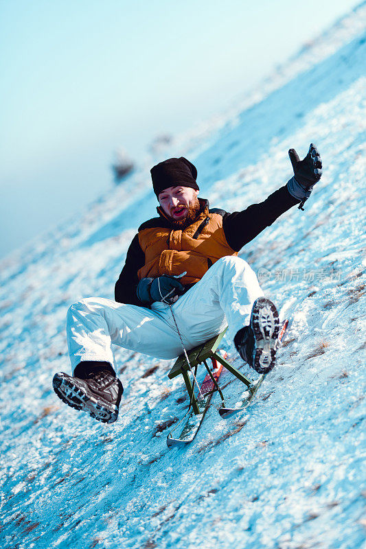 男性在雪坡上骑雪橇时尖叫