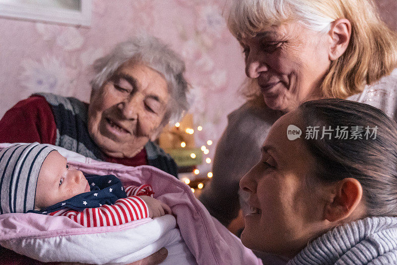 四代人一起在家过节。曾祖母，祖母，女儿和孙女聚在家里过圣诞节。COVID-19大流行期间的新生儿。特写肖像。