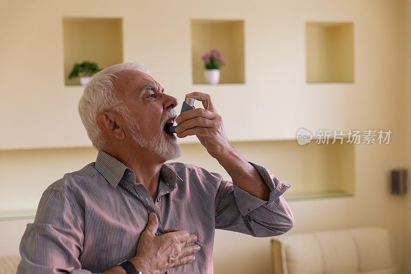 患有哮喘的老年男子有呼吸问题，所以他正在使用吸入器。