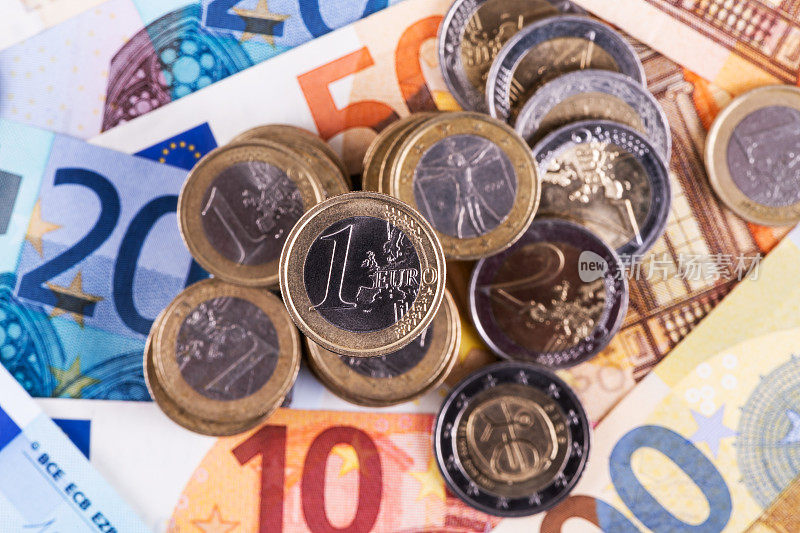 面值为1欧元和2欧元的硬币，以各种面额的欧元纸币为背景