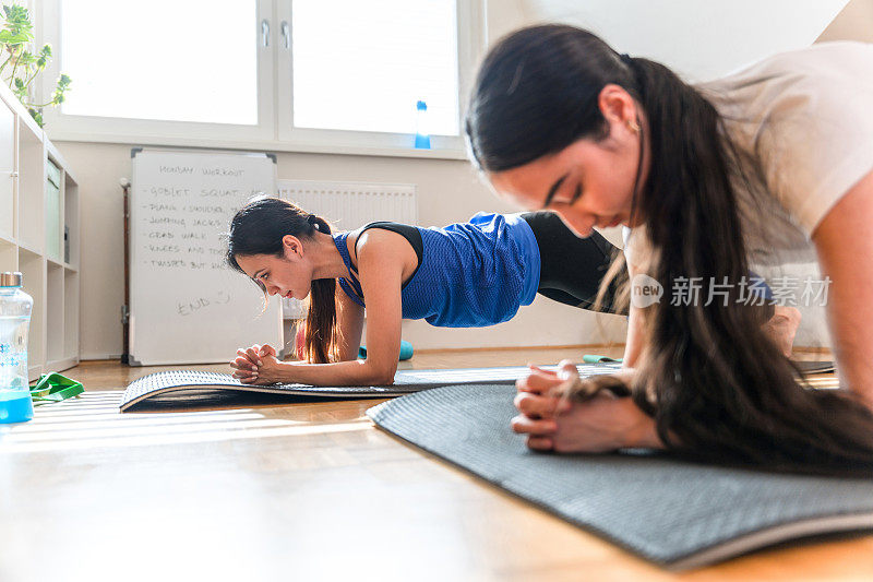 两位亚洲女运动员在家里做平板支撑和健身