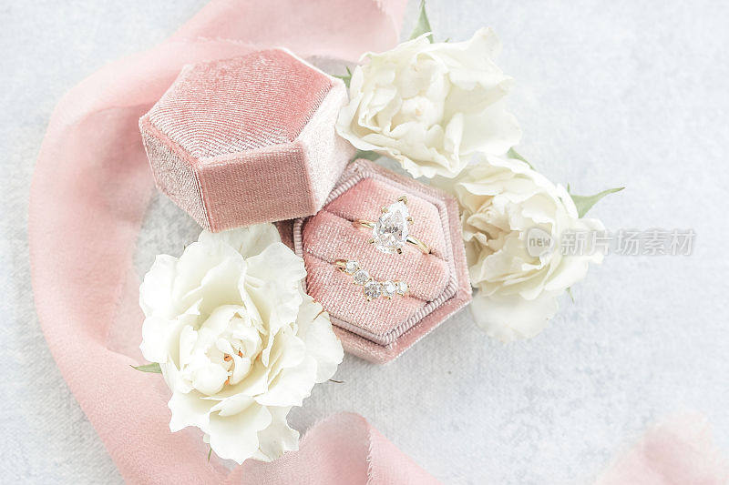带粉色盒子和白色花朵的结婚戒指