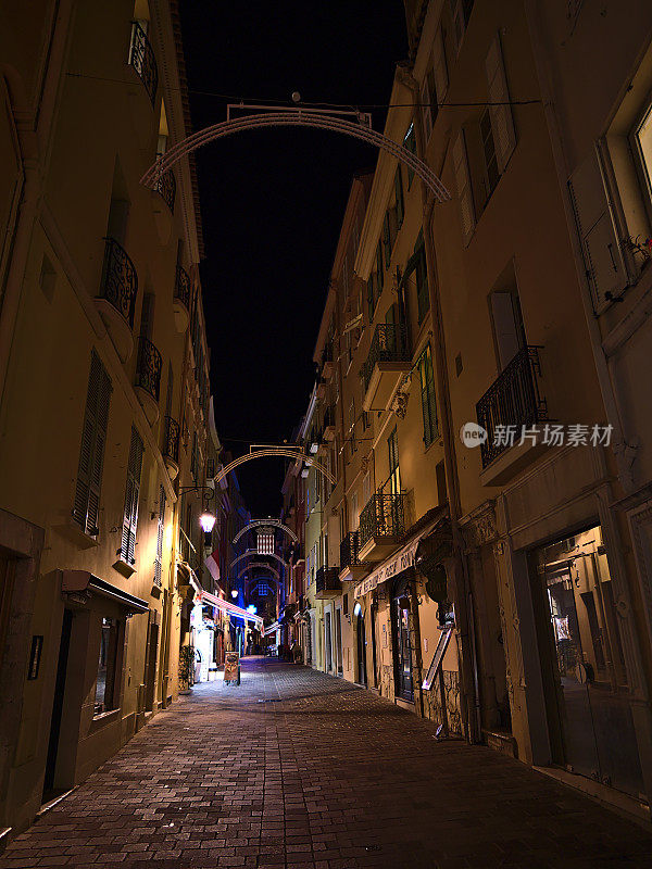 夜晚，在法国里维埃拉摩纳哥公国的历史建筑中，摩纳哥老城区狭窄小巷的夜景与递减视角。