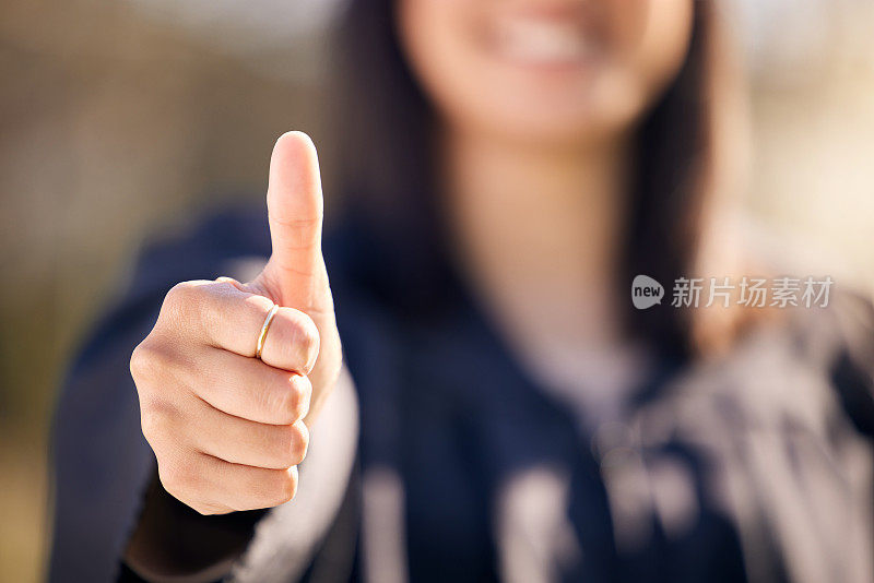 一个不认识的女人在毕业典礼上竖起大拇指的照片