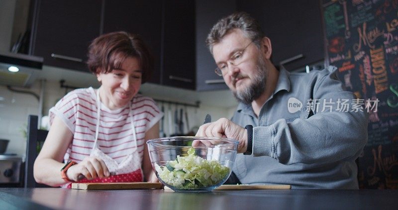 成熟的夫妇一起准备食物