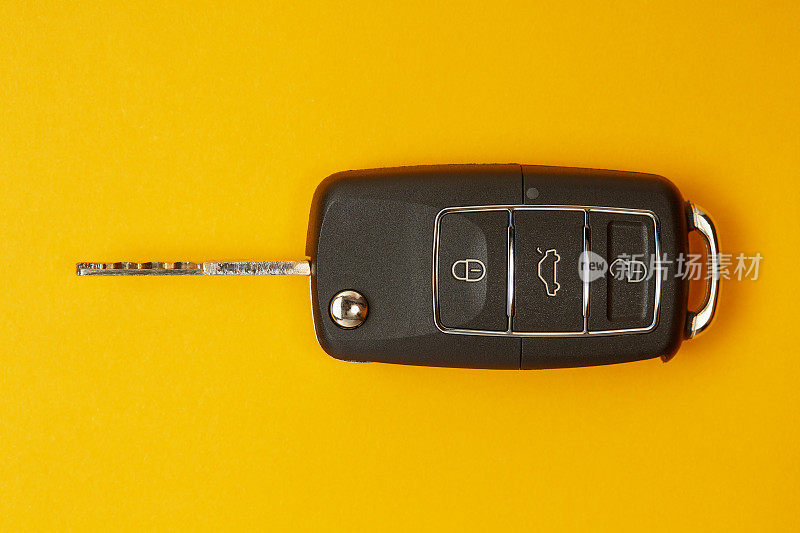 黄色背景的汽车钥匙，可遥控锁或开锁汽车和打开汽车后备箱