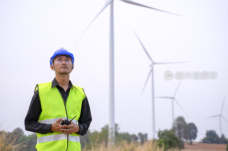 电力工地的蓝领工人。风车。