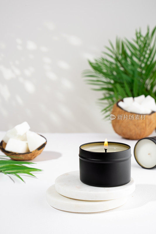 白色背景，黑色罐子里的椰子蜡蜡烛。天然环保椰子蜡蜡烛。时尚的概念。极简主义者。等角投影。副本的空间。
