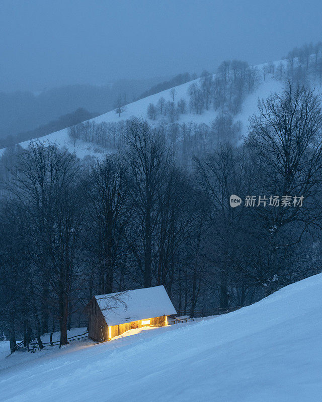 冬日雪林中孤独的山间小屋