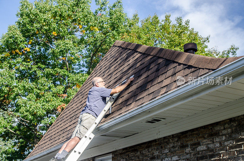 成熟男子修补沥青瓦屋顶