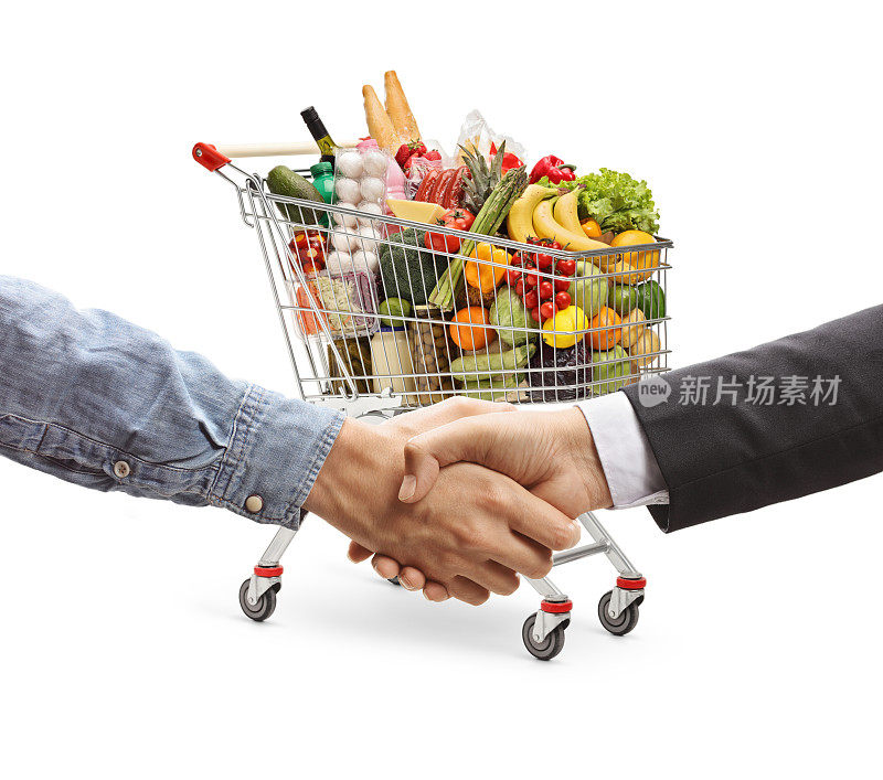 售货员在一辆装满食物的购物车前与顾客握手
