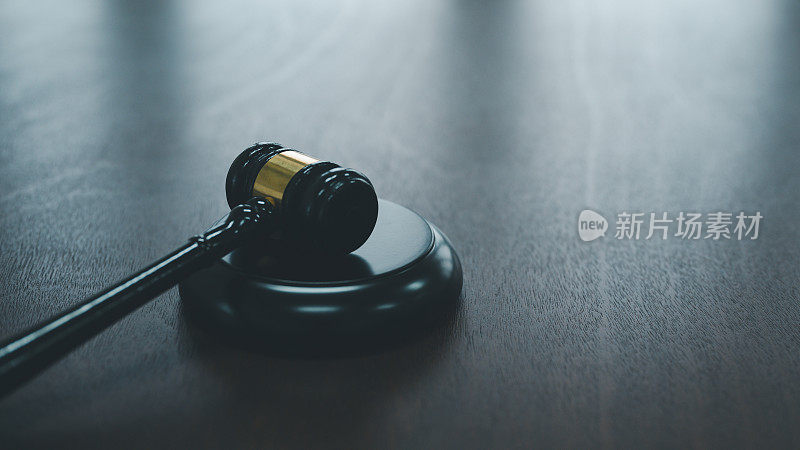 法官在法庭上权威性的木槌敲击带来了一种正义感和终结感，类似于拍卖商的木桌，象征着法律和秩序的概念。
