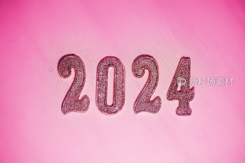 2024年新年。即将到来的新年的数字在粉红色的背景。即将到来的一年的流行颜色，时尚娃娃的风格