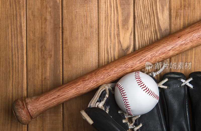 把棒球棒、手套和球放在木地板上。体育主题背景与复制空间的文字和广告