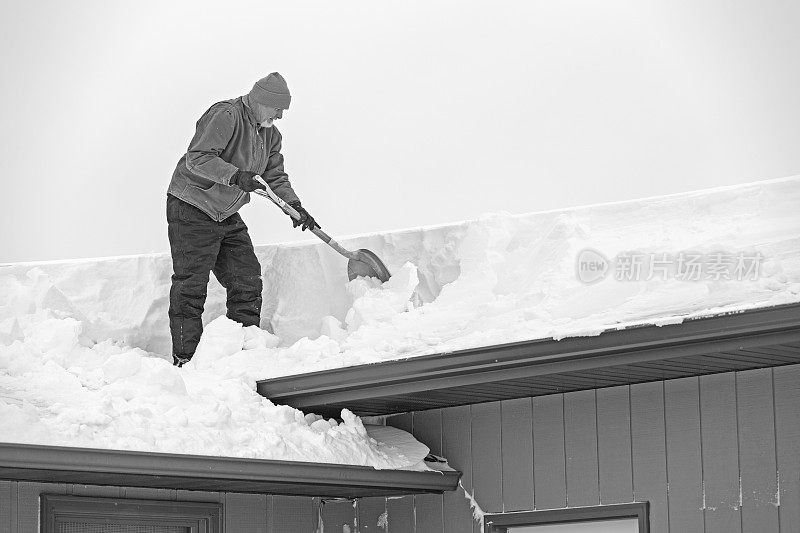 老人从屋顶上铲雪