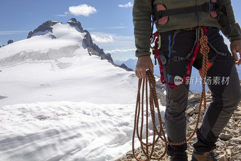 一位男性登山运动员到达了雪山的顶峰