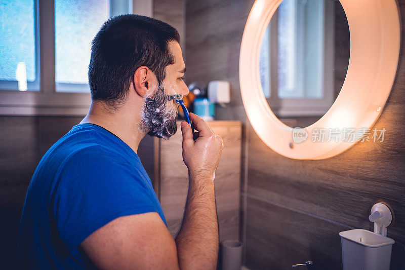 男人在浴室里刮胡子