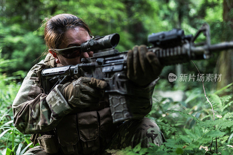 女兵在丛林中用M4卡宾枪瞄准