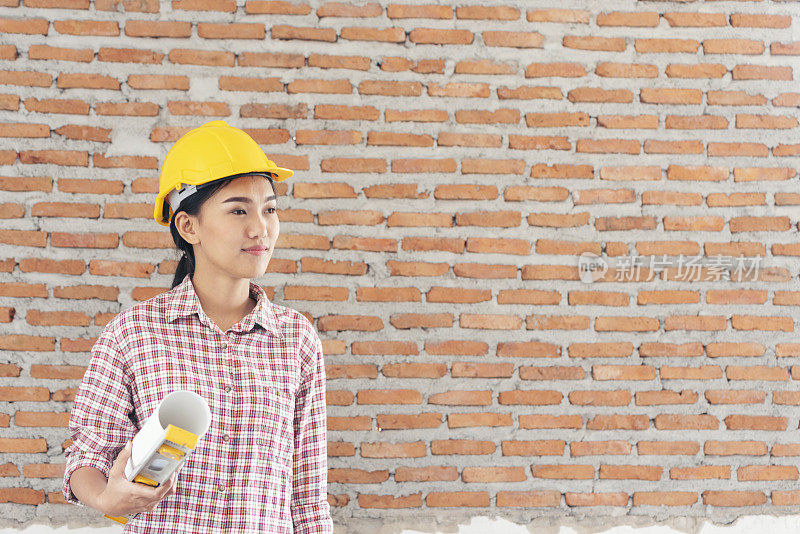 女建筑工程师在建筑工地上戴着安全白色安全帽。女土木工程师，带安全帽和安全帽。女性建筑工程师概念