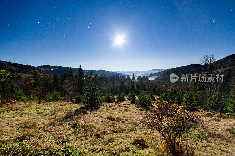 乌克兰山区的夜晚时间。月亮和星星与山的剪影在月亮和星星在黑暗的天空。