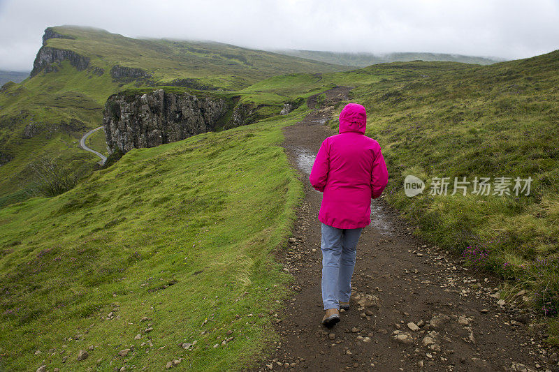 在苏格兰Skye岛的Cuith-raing山脉行走的资深女性徒步者的后视图，通常被称为Quiraing。