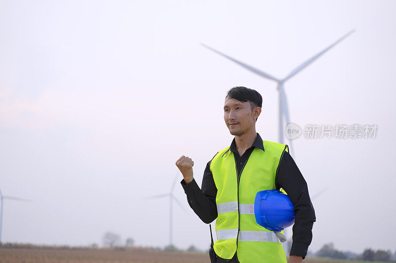 电力工地的蓝领工人。风车。