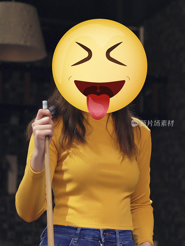 女人的肖像握着台球棍。她脸上有个吐舌头的表情。不能被识别。Emoji头的女人。