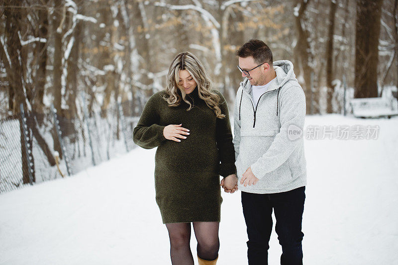一对夫妇和一个孕妇在冬天散步的肖像