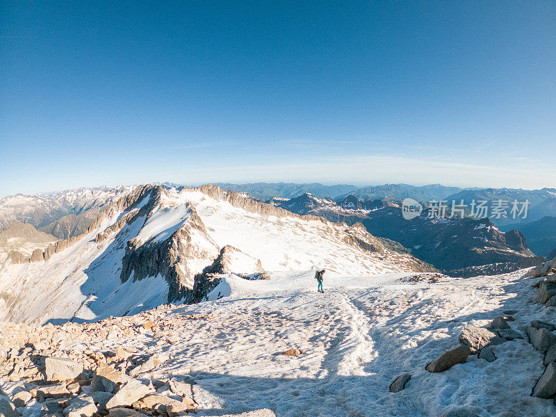 女登山者在雪道上攀登山峰