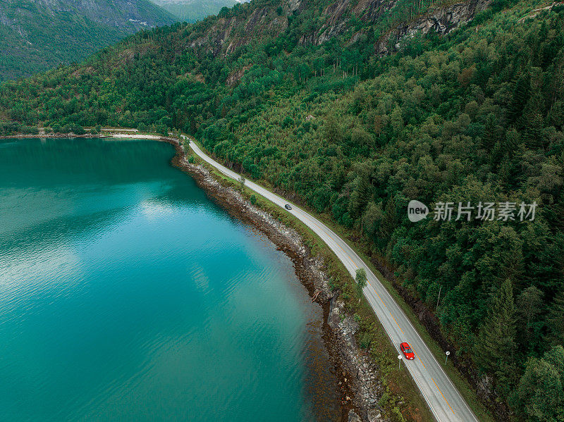 航拍的汽车在公路附近的湖在挪威日落