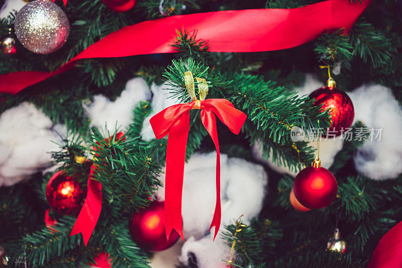 用红丝带和红色的圣诞球和银球装饰圣诞树。圣诞节的背景。新年概念。