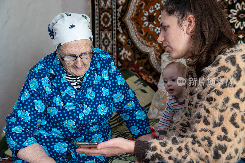 这位女士向她的祖母解释如何使用智能手机。