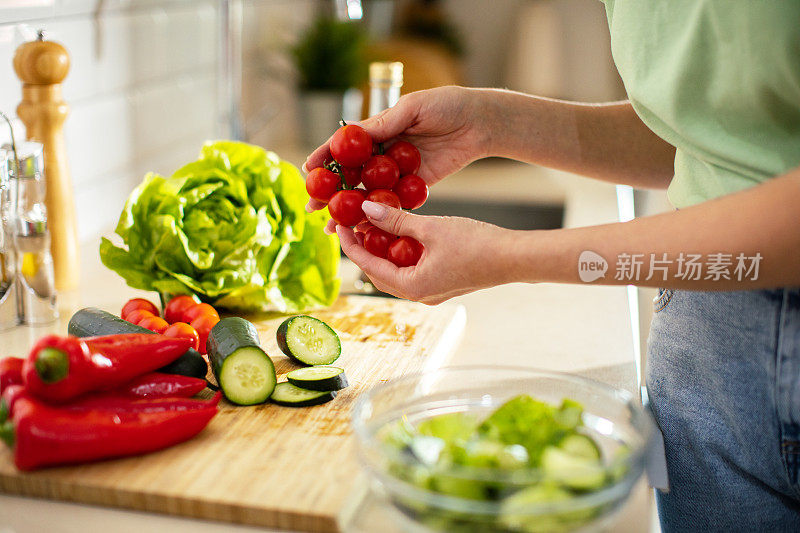 年轻女子在家里的厨房里切菜和准备蔬菜