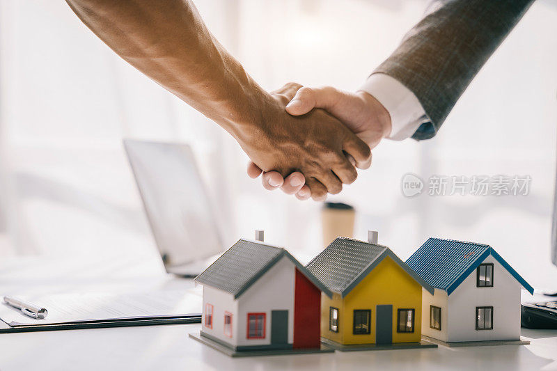 近距离握手，考虑买房，投资房地产。经纪人签署销售协议。代理，租赁协议，成功交易。