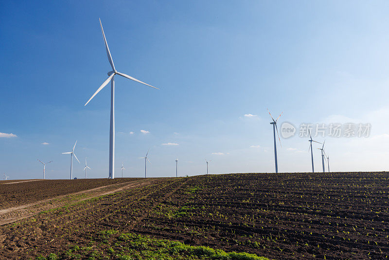 水平轴风力涡轮机在蔚蓝的天空下的农业领域
