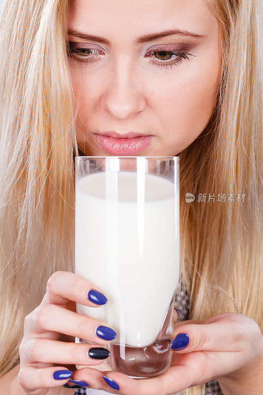 用玻璃杯喝牛奶的妇女