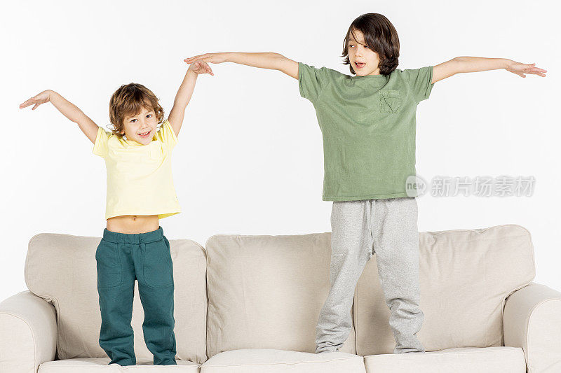 两个男孩在沙发上玩。