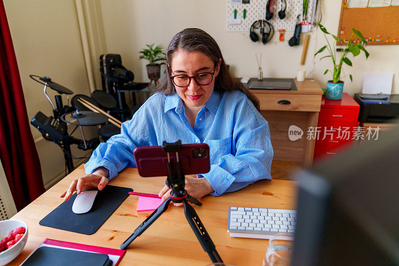 在家办公的女人把手机放在三脚架上