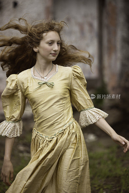 长发女孩穿着金色的丝绸连衣裙