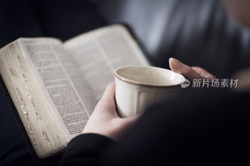 女人读圣经和喝茶或咖啡