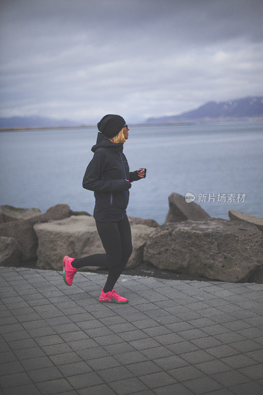 在冰岛奔跑的年轻女子运动员。