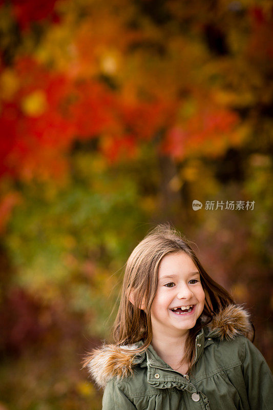 秋天的一天，小女孩站在外面笑着