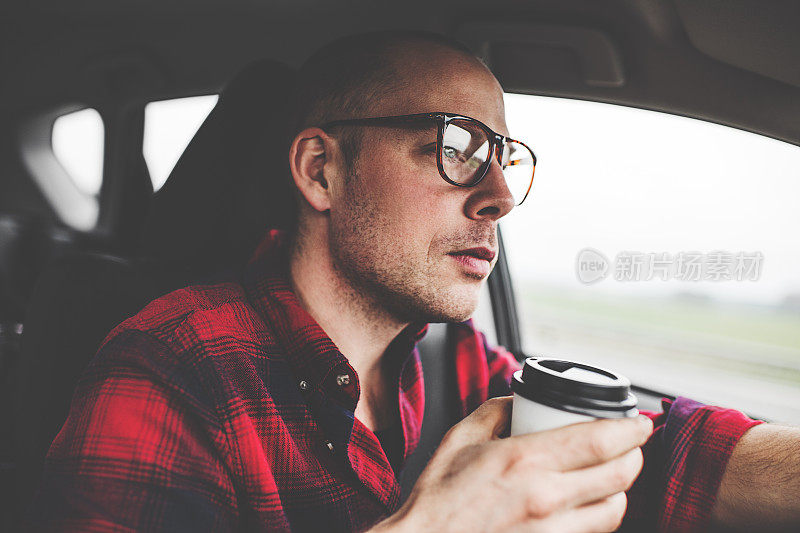 一边开车一边喝咖啡的男人