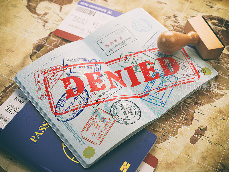在世界地图上盖有拒签印章的护照