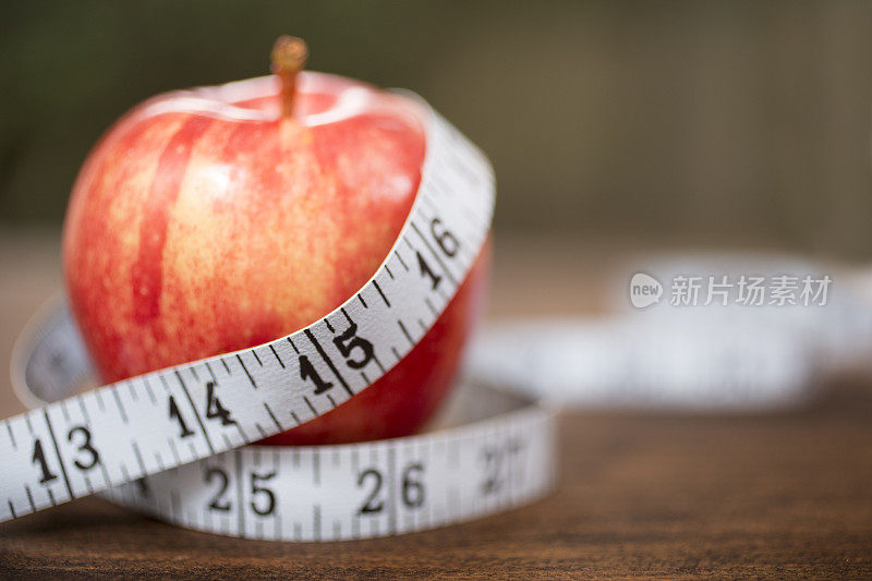 以红苹果和卷尺为主题的节食场景。