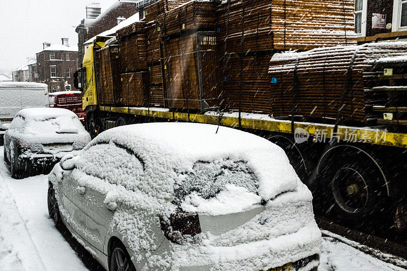 汽车和卡车在积雪的街道上行驶