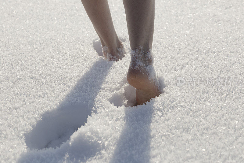 赤脚在雪地里行走的女性